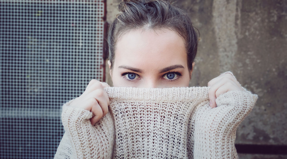 woman covering her nose with her sweater